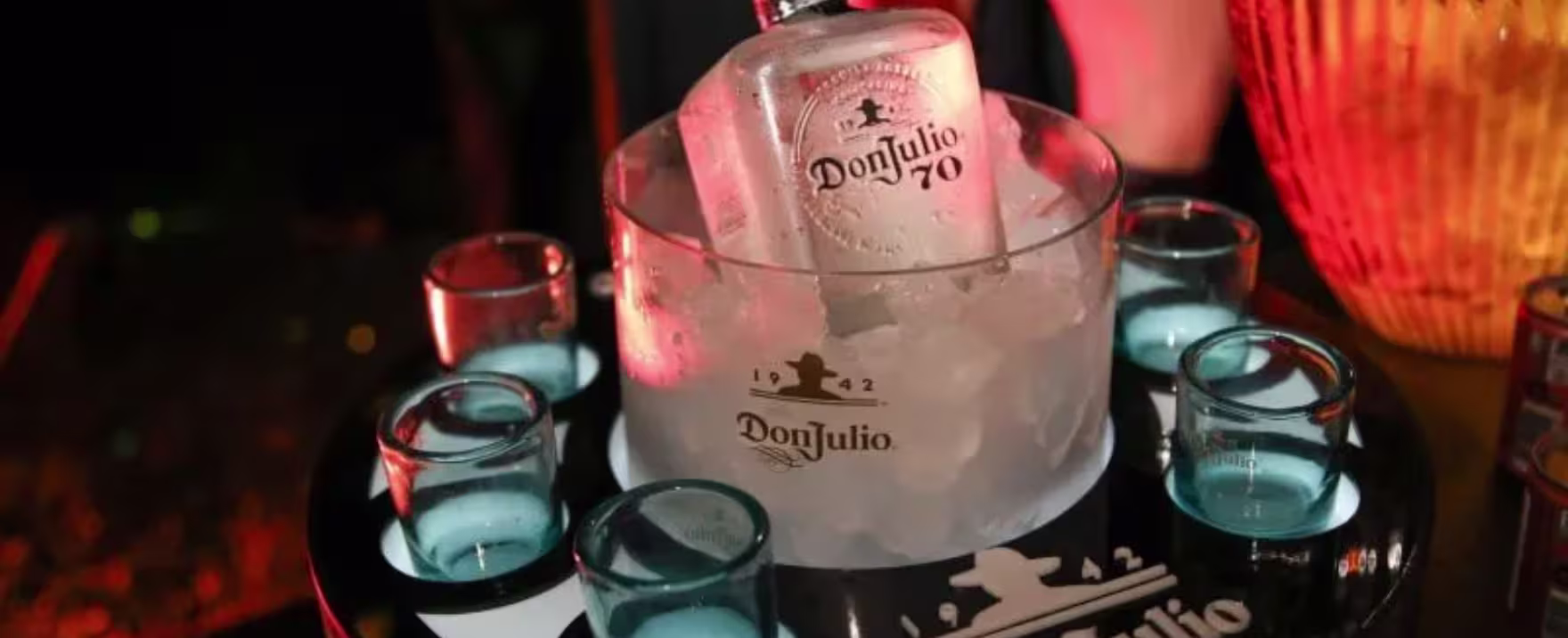 La imagen muestra un cartel luminoso de Don Julio y luces alrededor.