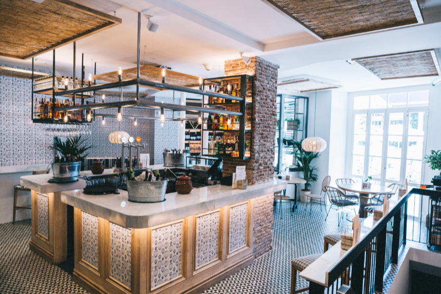 Interior de La Bientirada, con barra central luminosa, detalles decorativos modernos y un ambiente fresco y acogedor.