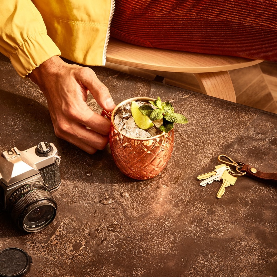 A Moscow Mule in a copper cup on a wooden table