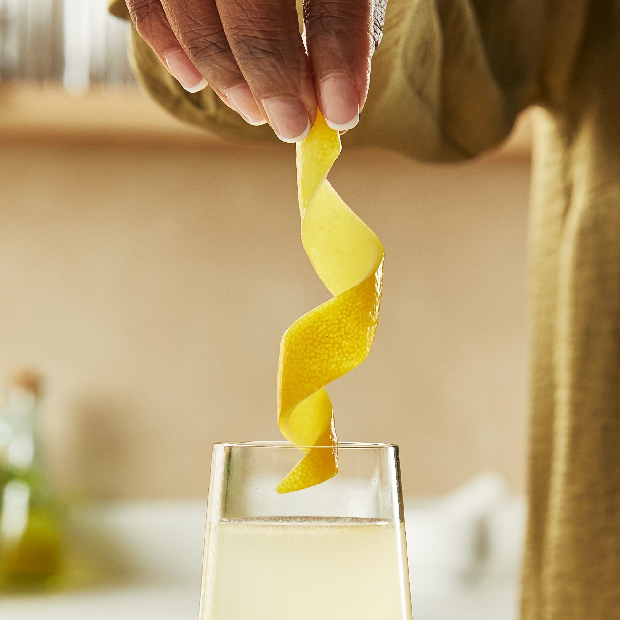 O coajă uriașă de lămâie este coborâtă într-un pahar