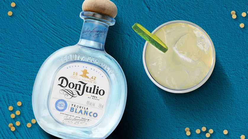 La imagen muestra una botella de tequila Don Julio Blanco junto a un vaso relleno con el cóctel Margarita.