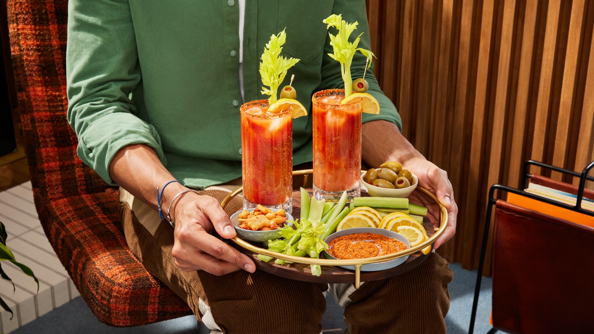 A man carries a tray with two Bloody Mary cocktails