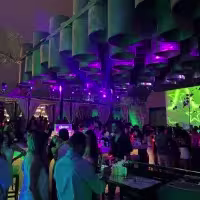 En la imagen se ve uno de los espacios exteriores de Café del Mar. Con luces color morado, mezclado con tonos verdes