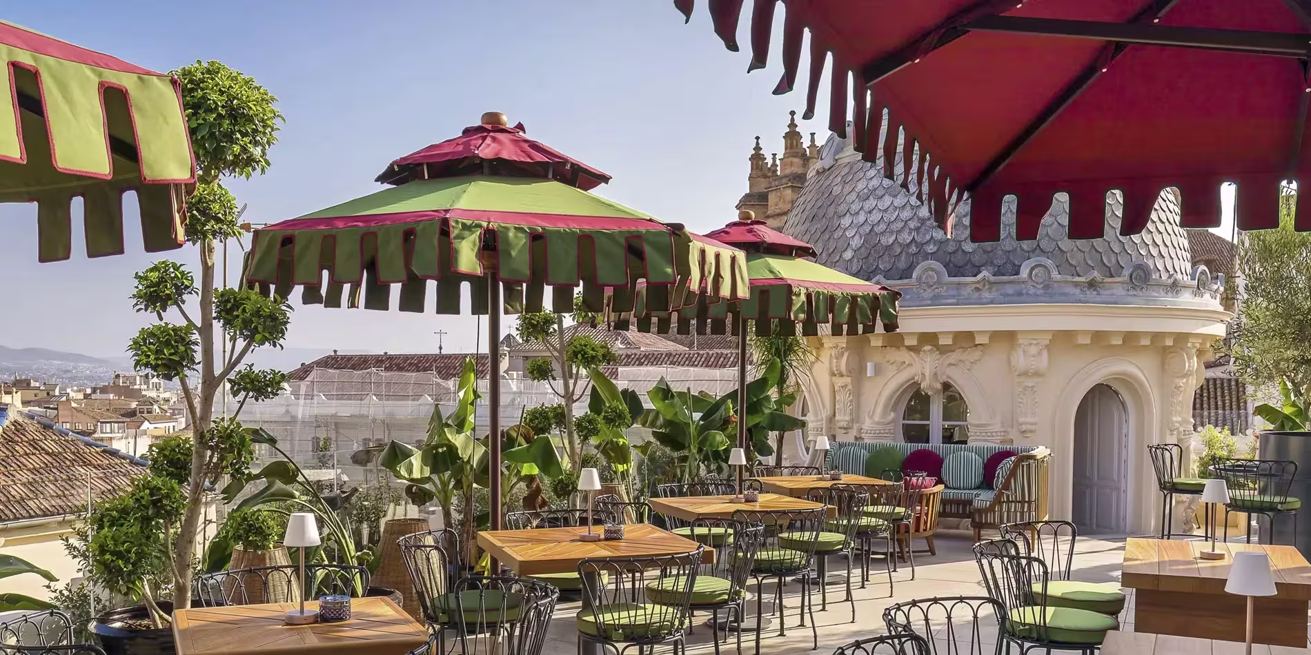 La imagen muestra la "Terraza Miralba" al atardecer, con mesas elegantemente dispuestas, vegetación exuberante y una atmósfera relajada y sofisticada.