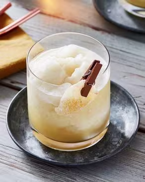 A Penicillin cocktail in a rocks glass with a candied ginger garnish