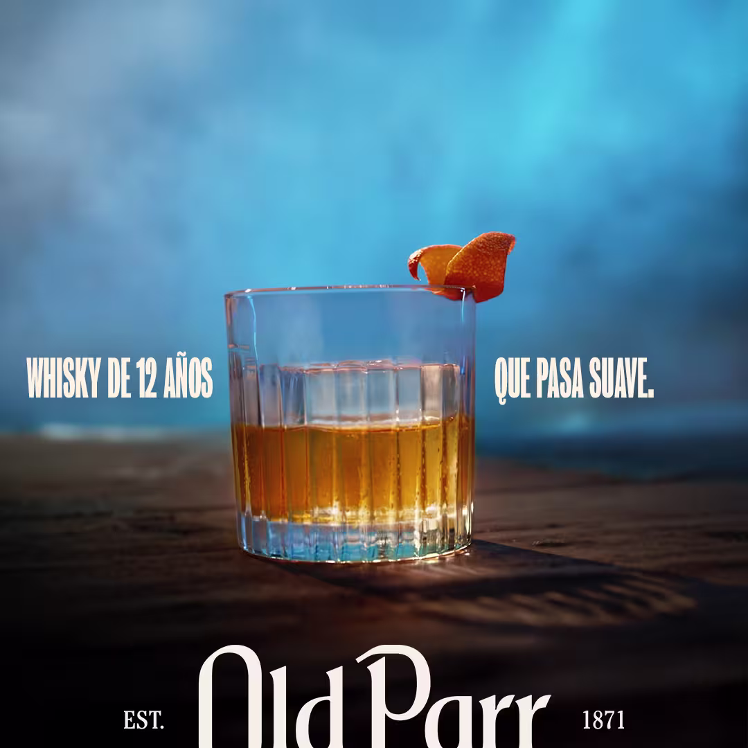 Vaso de Old Parr 12 años servido en las rocas con twist de naranja, campaña "Whisky de 12 años que pasa suave" 