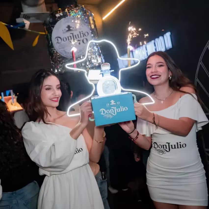 Dos mujeres sosteniendo una botella de Don Julio Blanco