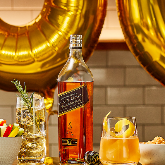 La imagen muestra una botella de whisky Johnnie Walker y dos vasos rellenos con cócteles preparados con dicho destilado.