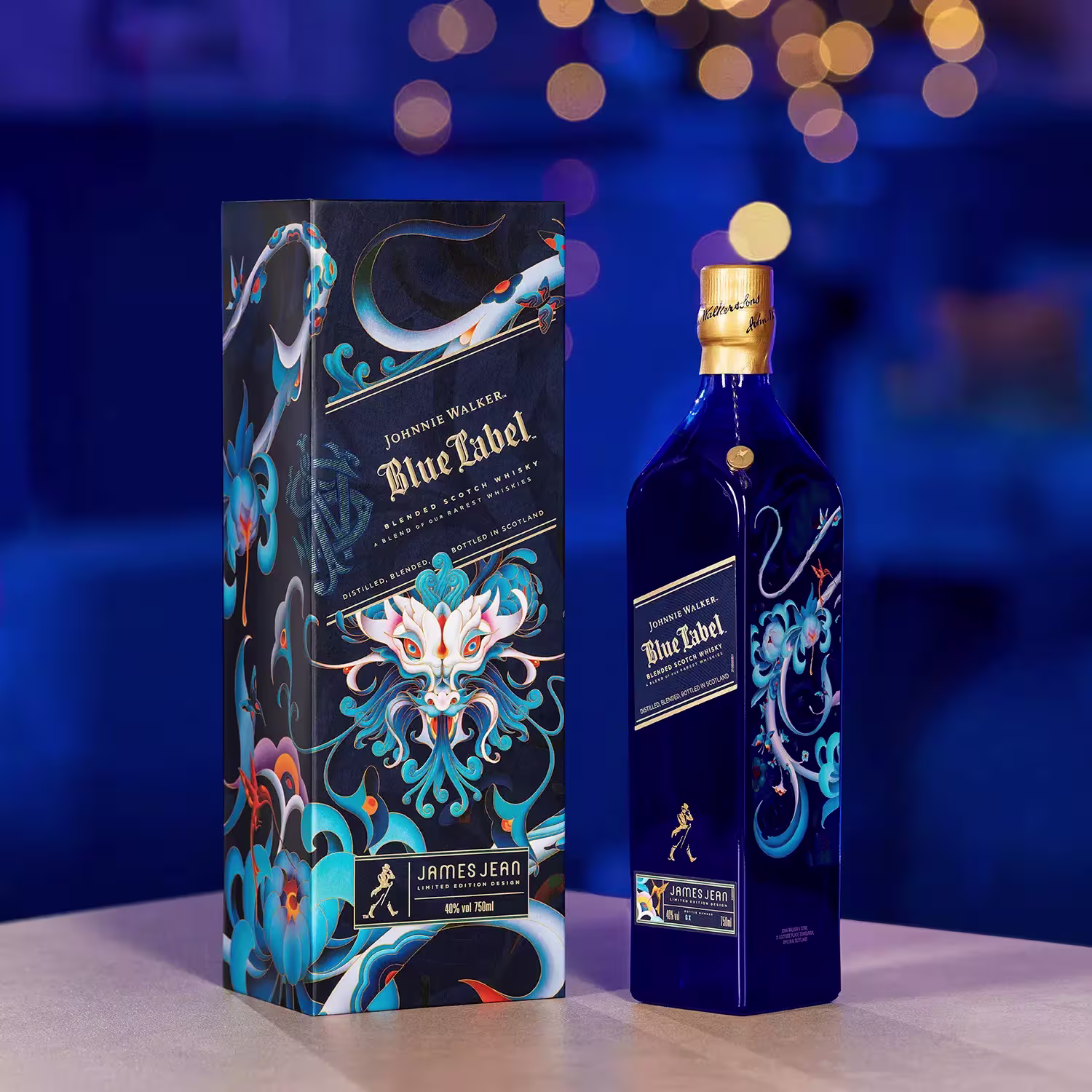 A bottle of Johnnie Walker Blue Label with decorative blue and gold artwork stands next to its matching box on a table; blurred lights in the background.