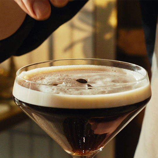 Un martini espresso al ron adornado con granos de café.