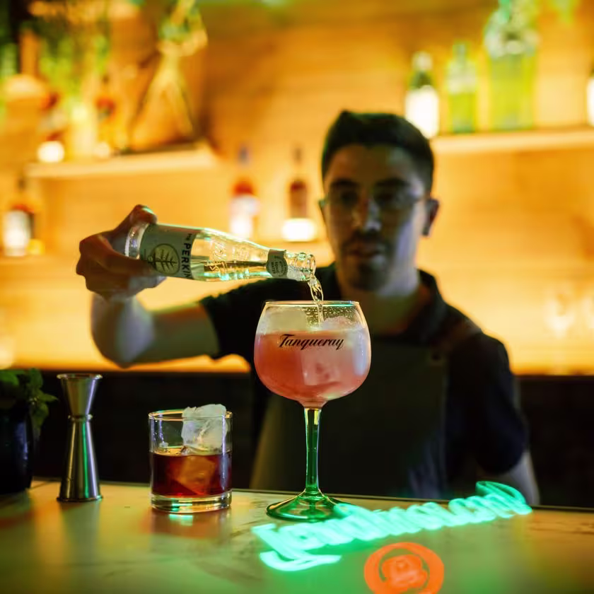 El barman vierte agua tónica en un Gin Tonic servido en una copa de vidrio de Tanqueray, en el bar "Don Nico" en Lima, Perú.