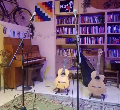 Kaf Café, un rincón cultural con estanterías de libros, guitarras y micrófonos listos para eventos de música en vivo, poesía y espectáculos íntimos.