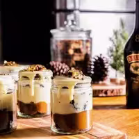 La imagen muestra una botella de Baileys Original Irish Cream y distintos frascos rellenos con cócteles preparados con dicho destilado.