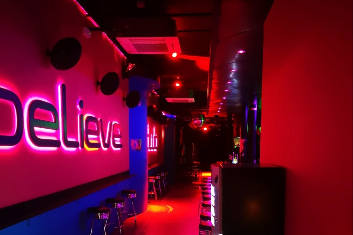 Pasillo con luces de neón y ambiente moderno en Believe Club, con colores vibrantes y diseño minimalista para disfrutar la noche