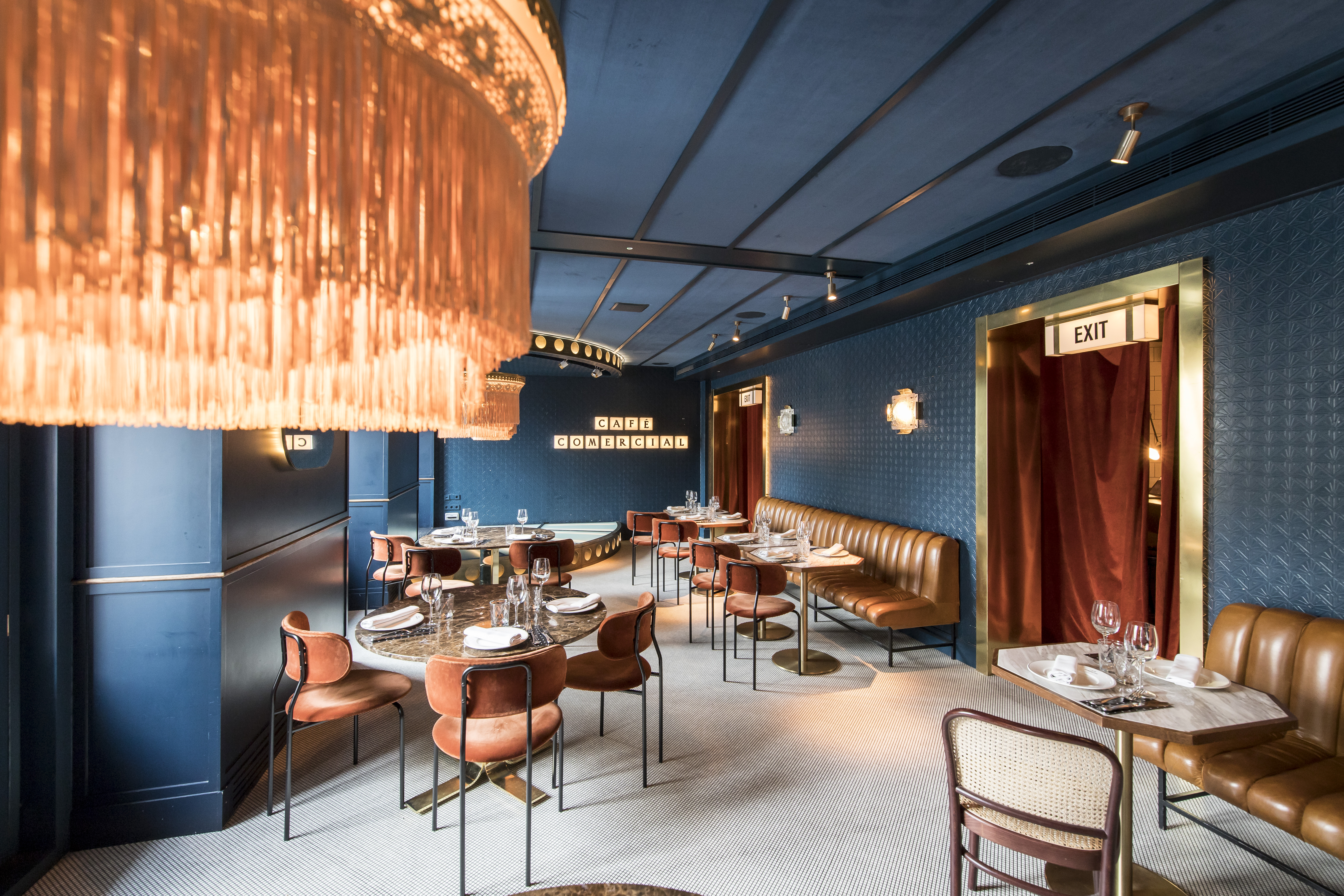 The Bar | Café Comercial - Plato de arroz con pato servido en Café Comercial, acompañado de copas de vino y guarniciones en una mesa elegantemente puesta.