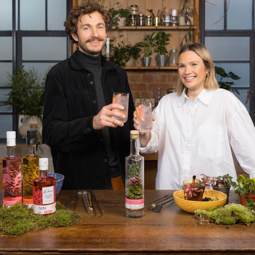 man and womane with glassess of chase cokctail and terrarium