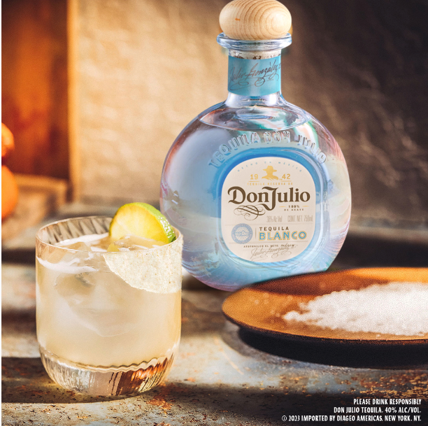 En la imagen se ve la botella de Don Julio Blanco, un plato con sal gruesa delante y un vaso con el trago, decorado con una rodaja de limonada
