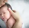 Mutter hält neugeborenes Baby sicher auf dem Arm