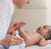 Inhaltsstoffe in Pampers Feuchttüchern: Mutter reinigt ihr Neugeborenes Baby mit Feuchttüchern. 