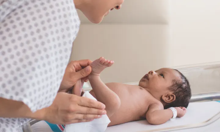 Inhaltsstoffe in Pampers Feuchttüchern: Mutter reinigt ihr Neugeborenes Baby mit Feuchttüchern. 