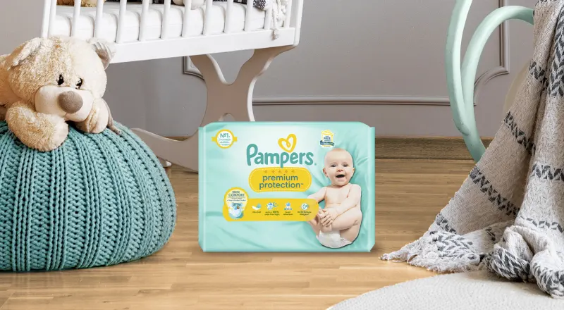 Pampers Premium Protection Packung in einem Babyzimmer.