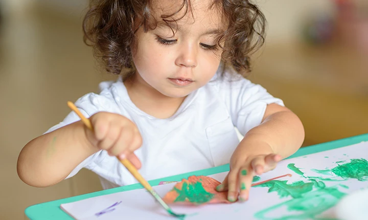 Kind malt mit Wasserfarben