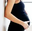 Schwangere Frau hält mit den Händen Ihren Bauch