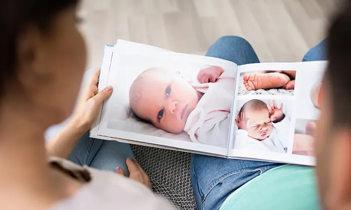 Eltern schauen sich die selbstgemachten Babyfotos an