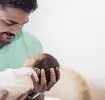 Vater hält Baby im Arm
