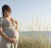 Schwangere Frau am Meer freut sich, denn es wird ein Junge