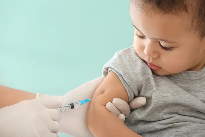Baby bekommt Impfung in den Oberarm gespritzt