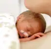 Frühgeborenes Baby liegt auf seiner Mutter