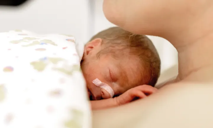 Frühgeborenes Baby liegt auf seiner Mutter