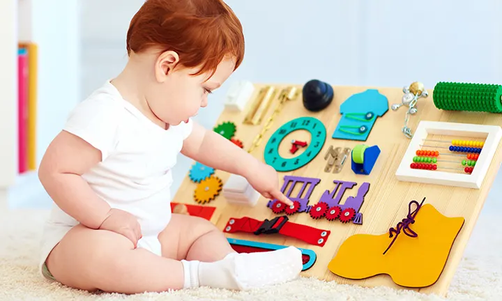 Baby entwickelt seine motorischen Fähigkeiten beim Greifspiel