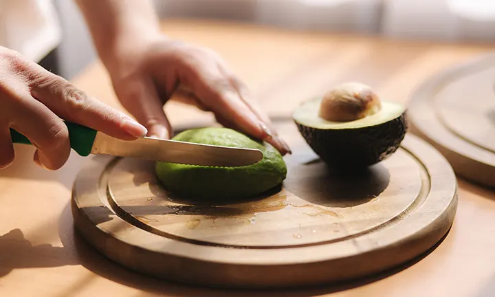 Schwangere Frau bei Zubereitung von Avocado