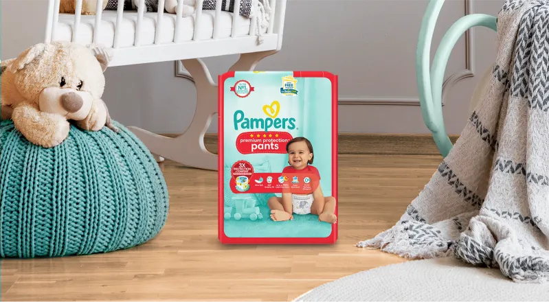 Pampers Premium Protection Pants Packung in einem Babyzimmer.