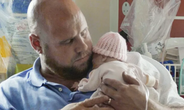 Vater hält sein frühgeborenes Baby im Arm