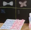 Eine Tafel sowie rosa und blaue Schleifen der Teams für tolle Babyparty-Spiele