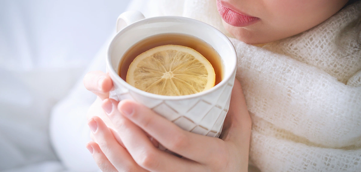 Overhead shot of person drinking tea to help soothe common cold symptoms