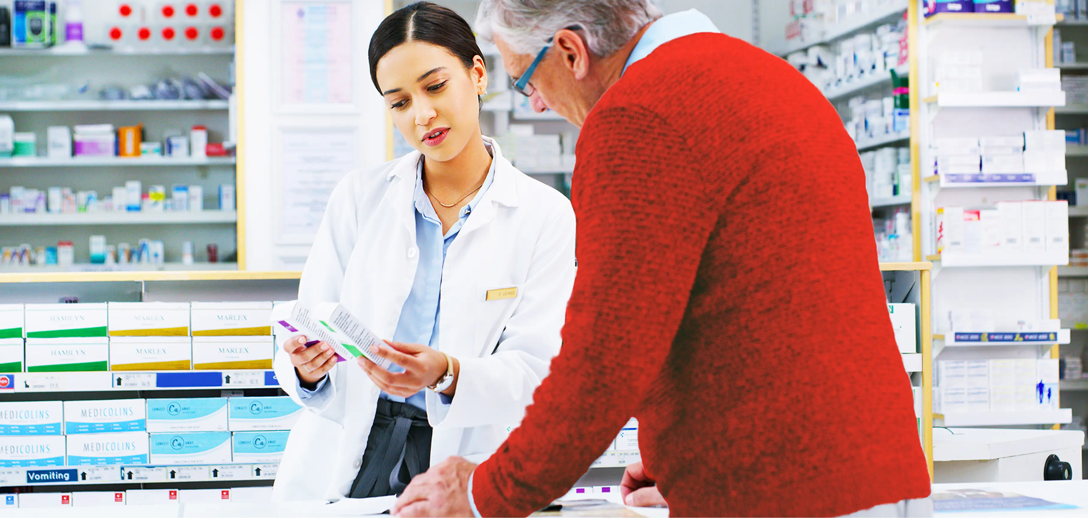 Pharmacist showing older customer medication
