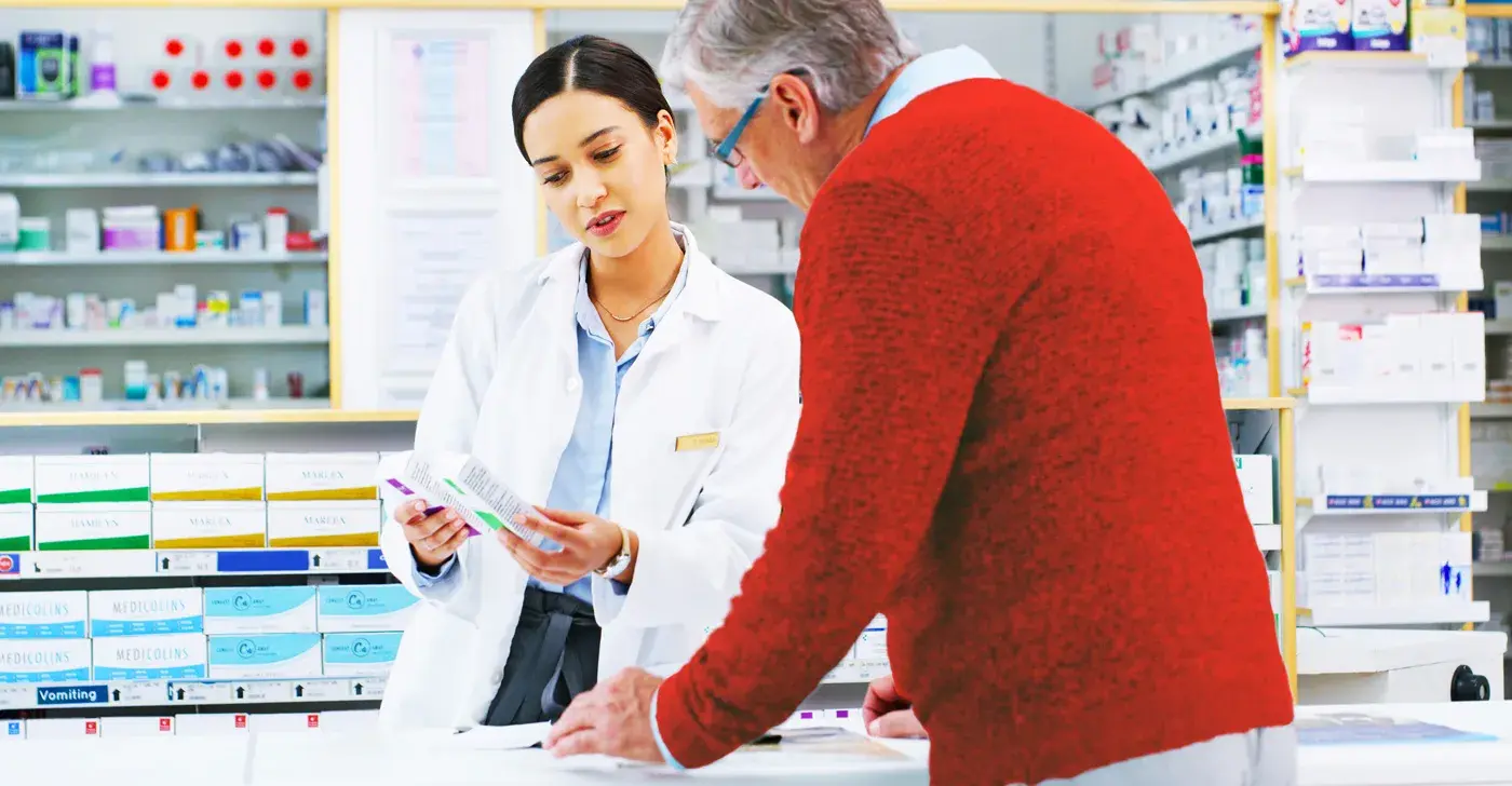 Pharmacist showing older customer medication