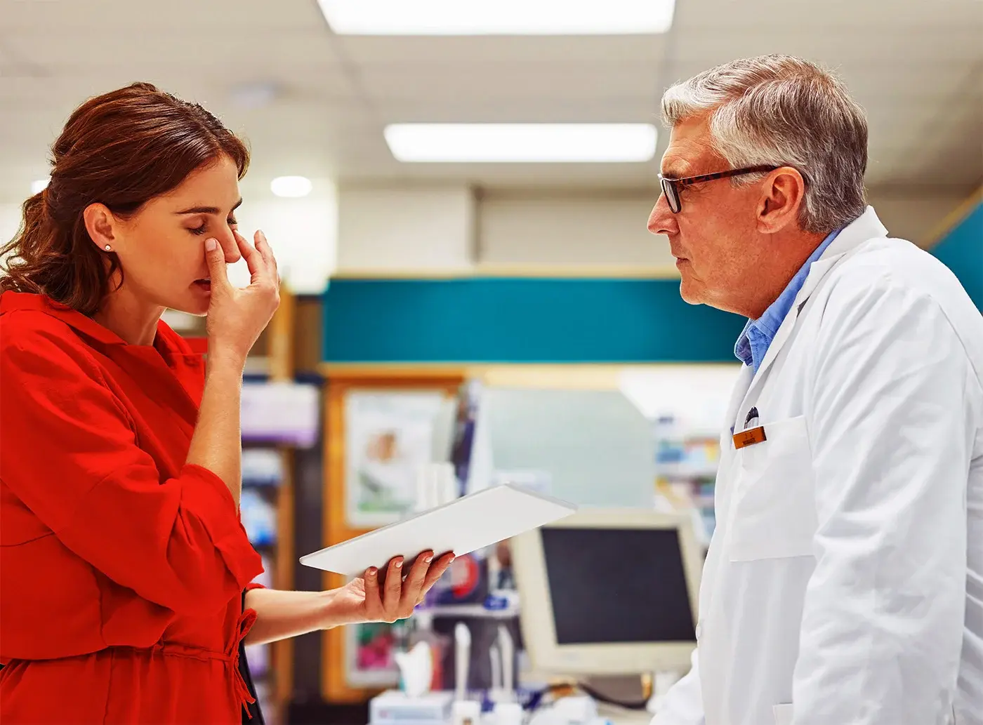 Woman experiencing sinus congestion holds her nose while consulting a pharmacist