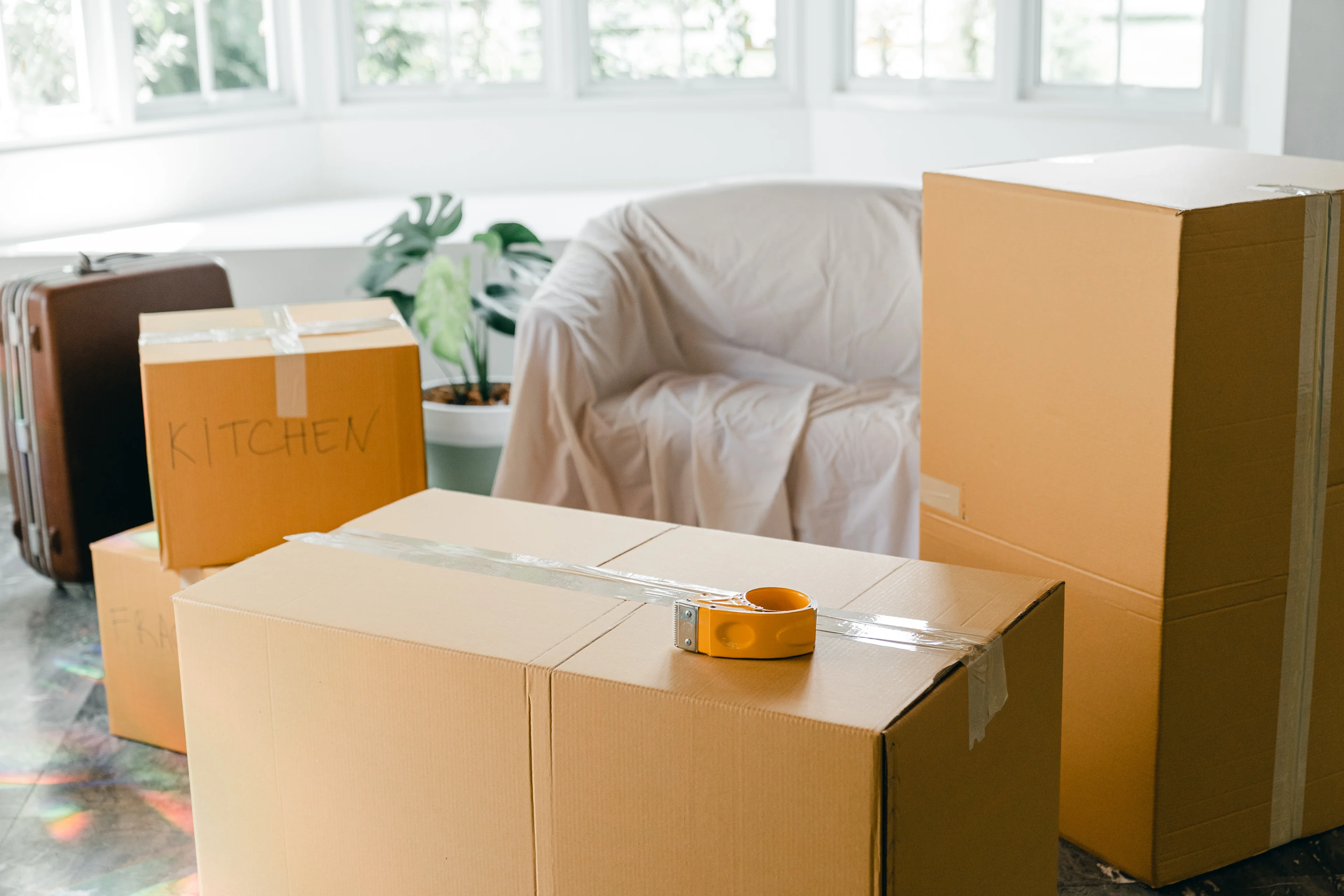 des cartons de déménagement et un canapé recouvert d'un drap en prévision du déménagement. 