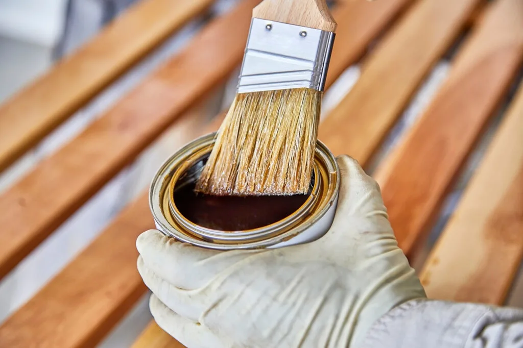 A painter adding varnish to the brush