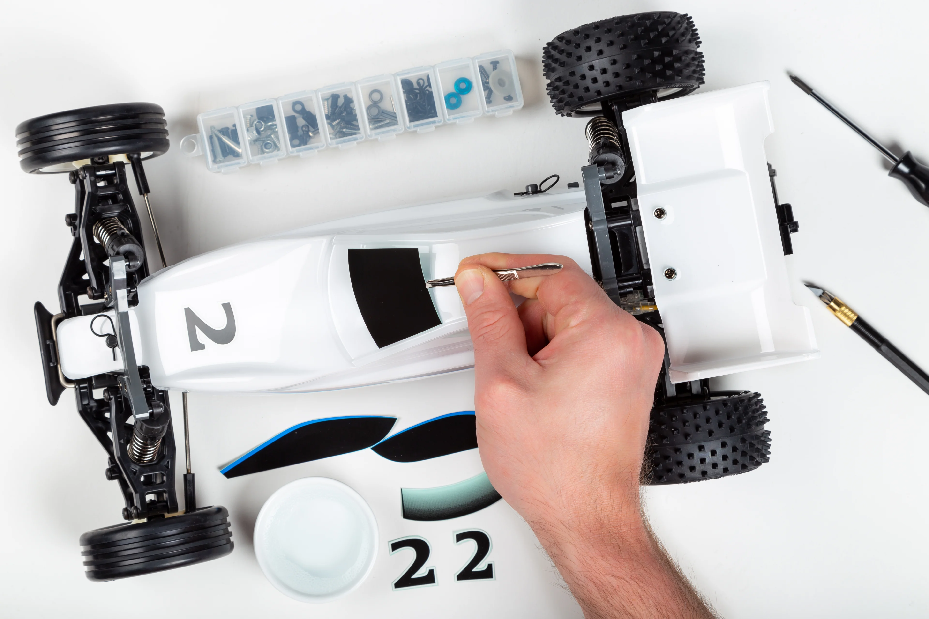 a person painting a remote control toy car. 