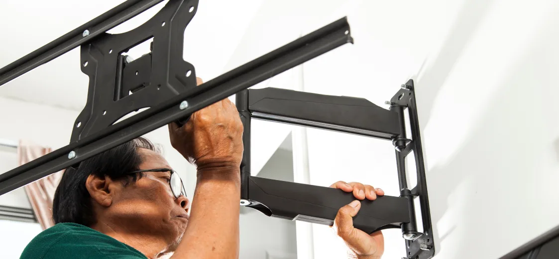 A picture of someone mounting an extending TV wall mount.