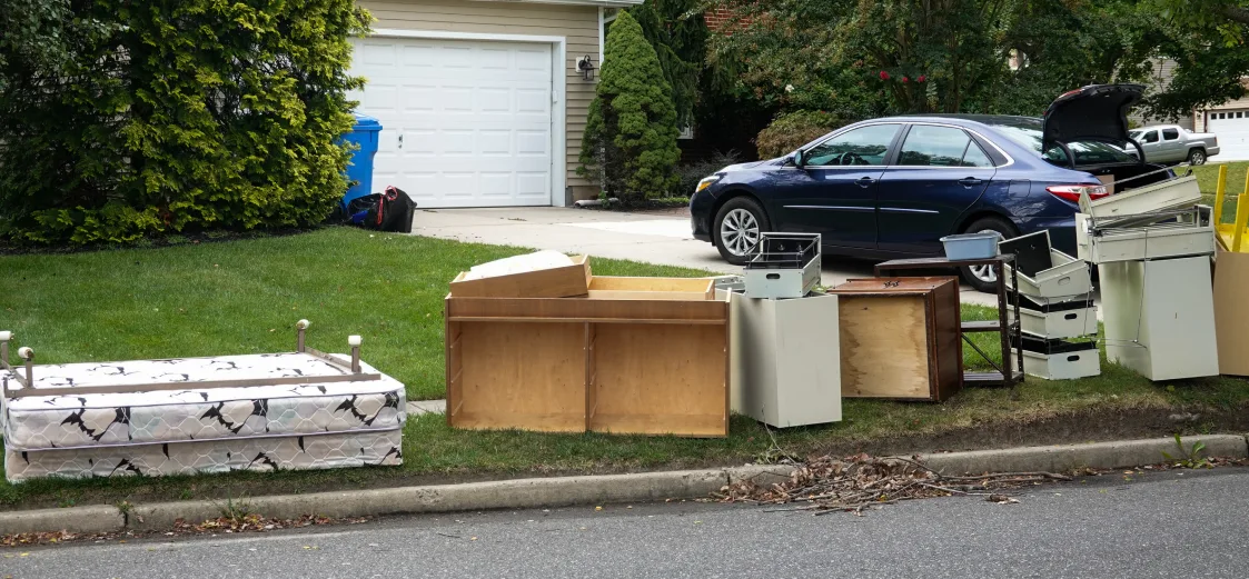 A picture of old cabinets and bed frames on the side of the road for junk removal