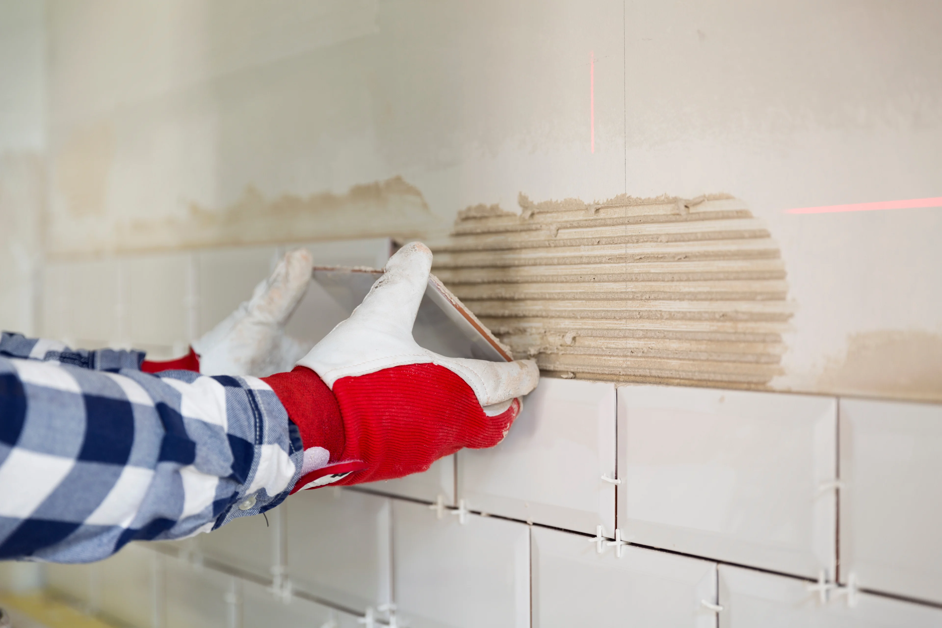 a person installing porcelain tile onto a wall