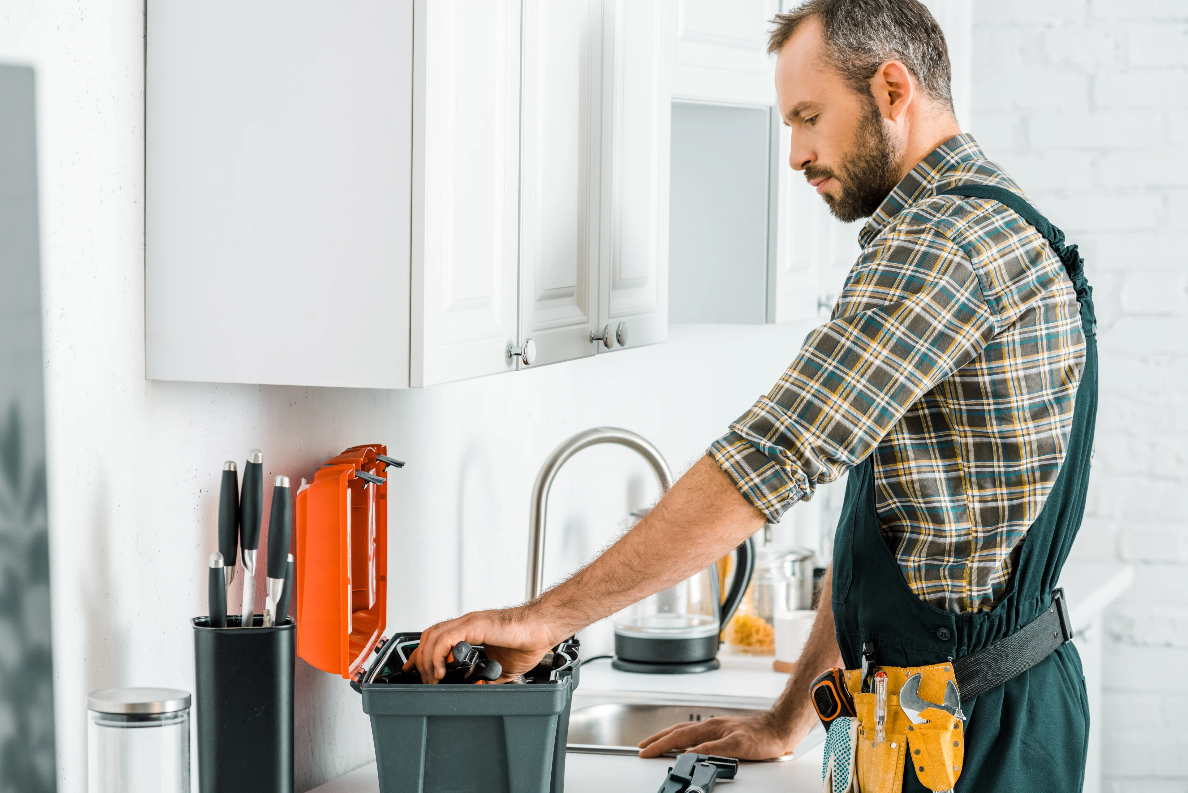 um faz-tudo com as respetivas ferramentas numa cozinha a preparar-se para um projeto