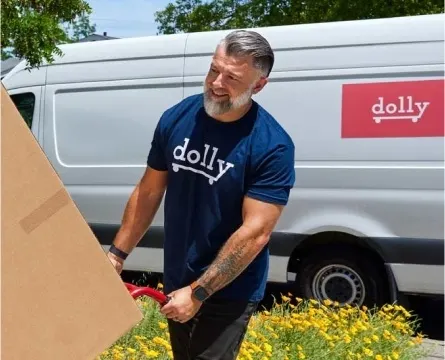 Man with a dolly t-shirt moving a big box using a dolly.